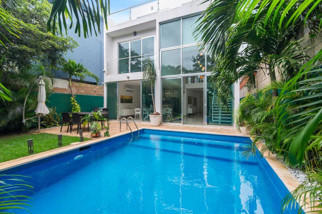 a swimming pool in front of a house at Casa Lula 5-BR Getaway in Riviera Maya in Playa del Carmen