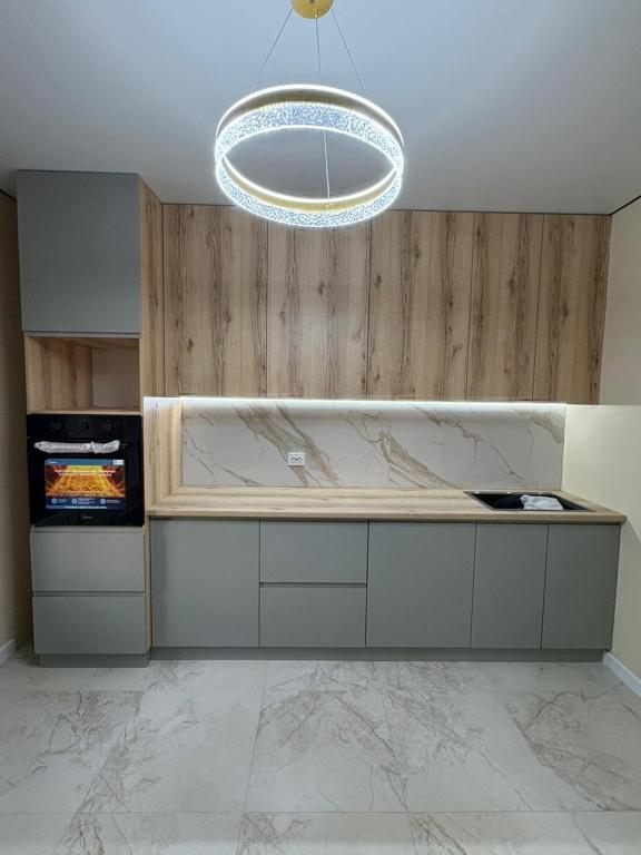 a kitchen with a marble counter and a chandelier at Turar apartments in Almaty