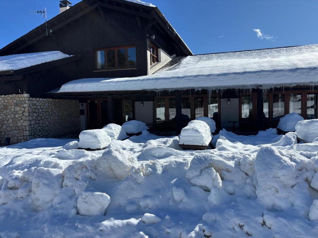 a pile of snow in front of a house at Hotel Golf Natura in La Coma i la Pedra