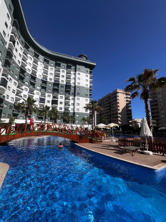 a swimming pool in front of a large building at Serenity Residens Two bedrooms in Alanya