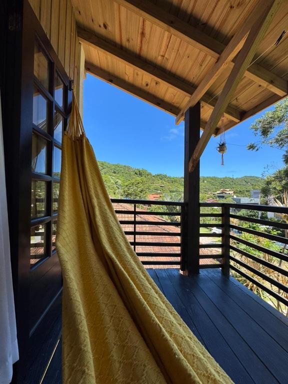 a hammock on a porch with a view at Pousada Vale da Praia in Praia do Rosa