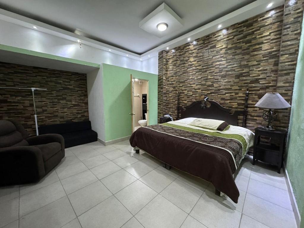 a bedroom with a bed and a brick wall at Comfortable apartment in downtown Reynosa in Reynosa