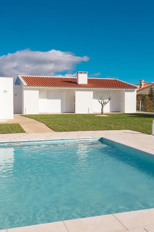 a swimming pool in front of a house at Casa da Pegada in Macedo de Cavaleiros