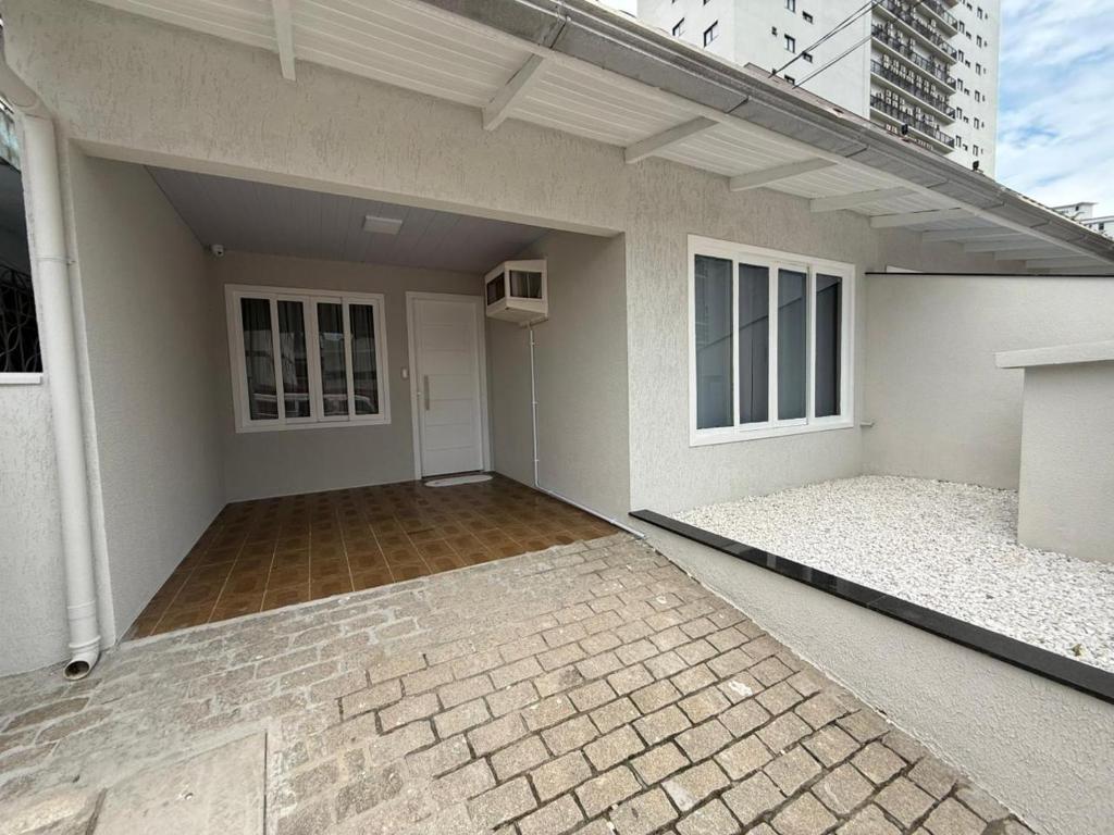 an empty house with a patio and a building at Chalé 01 centro de itapema 150m do mar in Itapema
