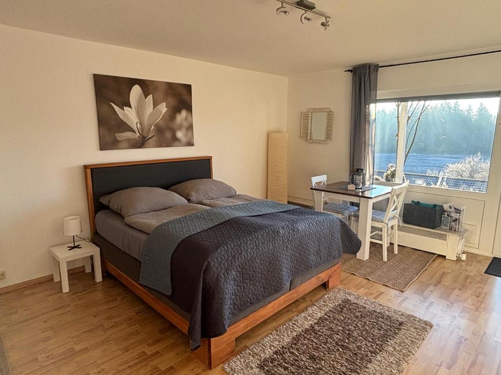 a bedroom with a bed and a desk and a window at Panorama-Haus Appartment PFÄNDER - Bergblick, Badezimmer, Kitchenette, eigene Sonnenterrasse in Wangen im Allgäu