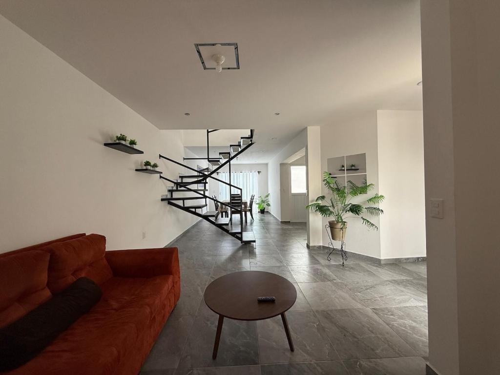 a living room with a couch and a spiral staircase at Casa Alejandra, Bernal Pueblo Magico in Bernal