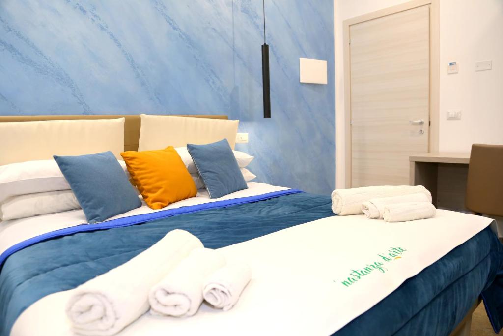 a bedroom with a large bed with towels on it at Nastanza D'arte in Mazara del Vallo