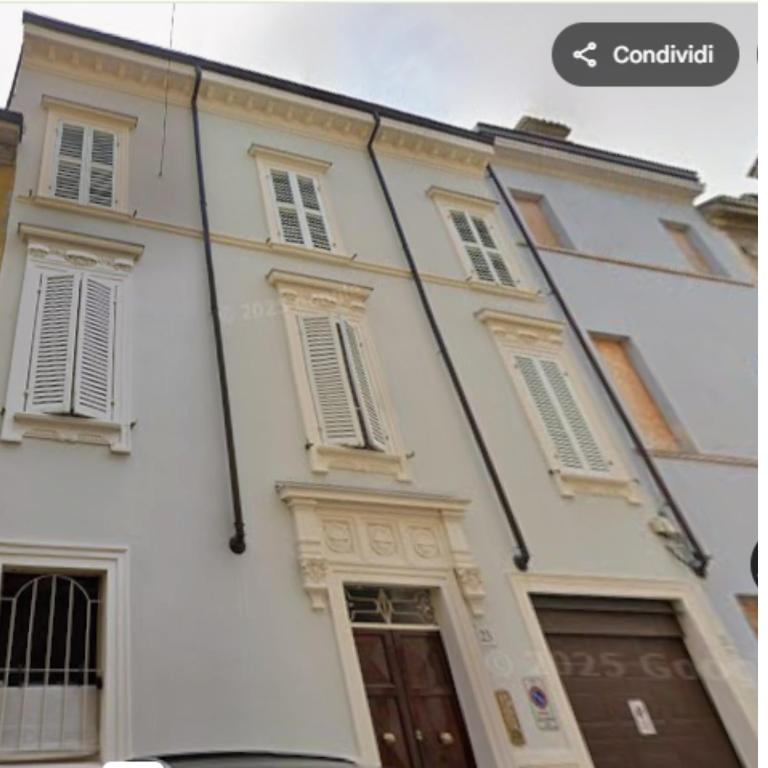 a white building with windows and a sign on it at Va Pensiero Cuore di Parma in Parma