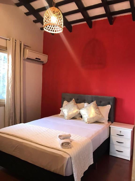 a bedroom with a bed with a red wall at Hotel Boutique 1970 in Asunción