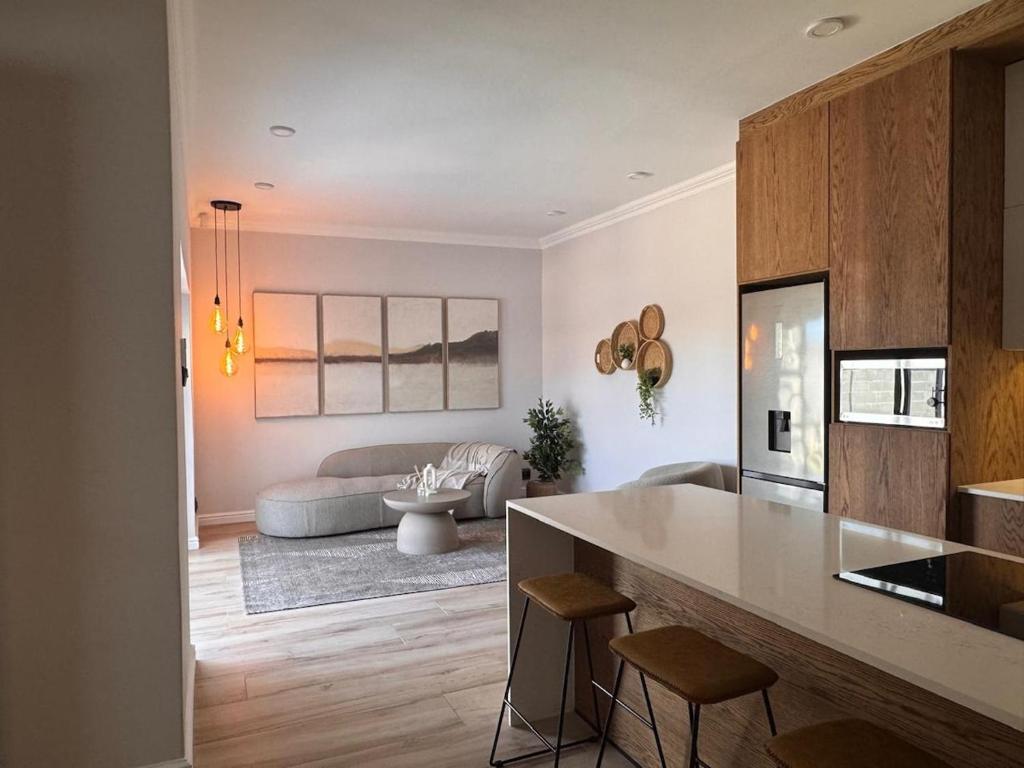 a kitchen and a living room with a couch at The Shirley in Gqeberha