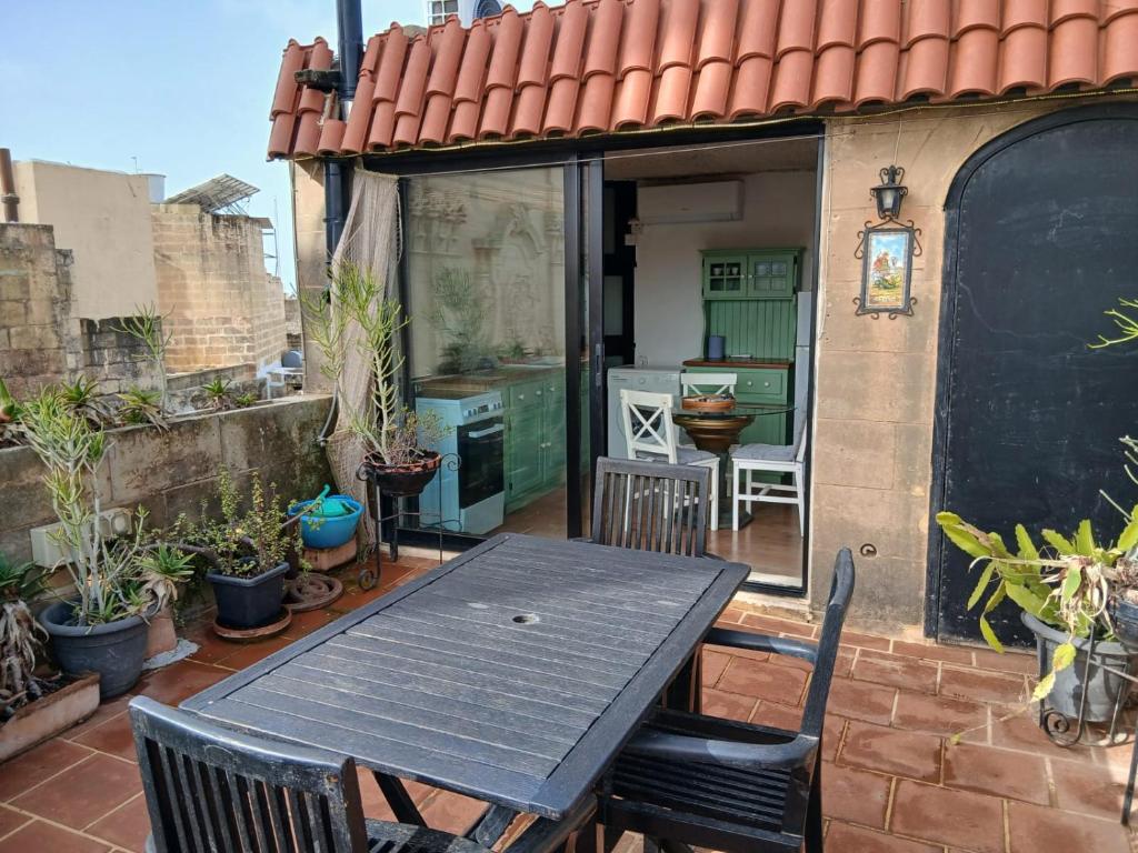 a table and chairs on a patio with plants at Gozo Duplex Studio overlooking historic Piazza in Victoria