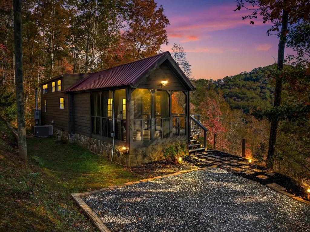 a small cabin in the woods at night at Eco Luxe Tiny Cabin with Big Mountain Views in Sylva