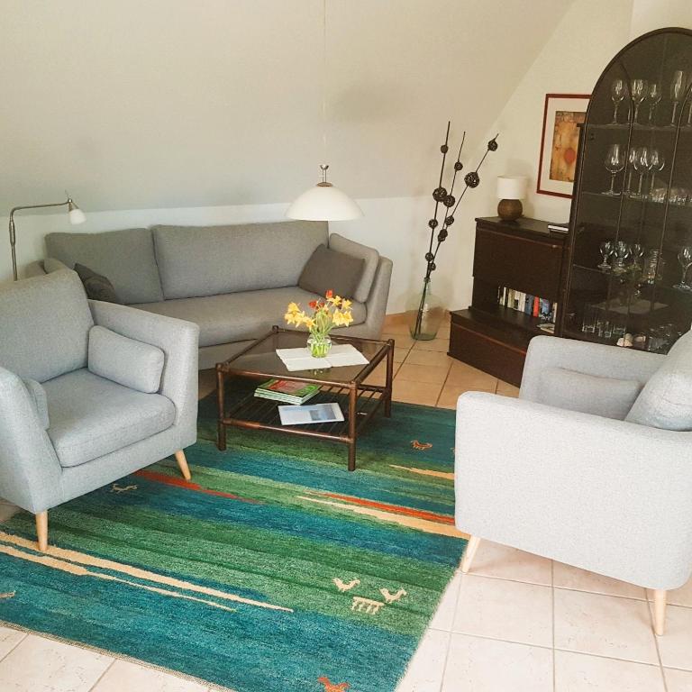 a living room with a couch and two chairs and a table at Nordseewohnung Strandloeper in Wittmund