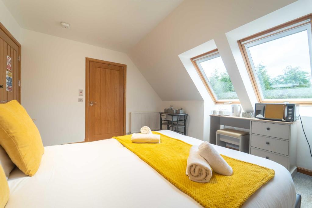 a bedroom with a bed with two towels on it at Ben View Room 3 in Fort William