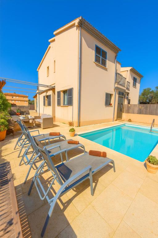 a pool with two lounge chairs next to a house at Can Angelica in Santa Margalida