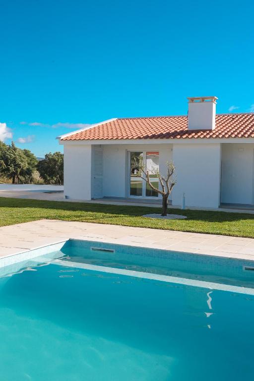 a swimming pool in front of a house at Casa do Pôr do Sol in Macedo de Cavaleiros