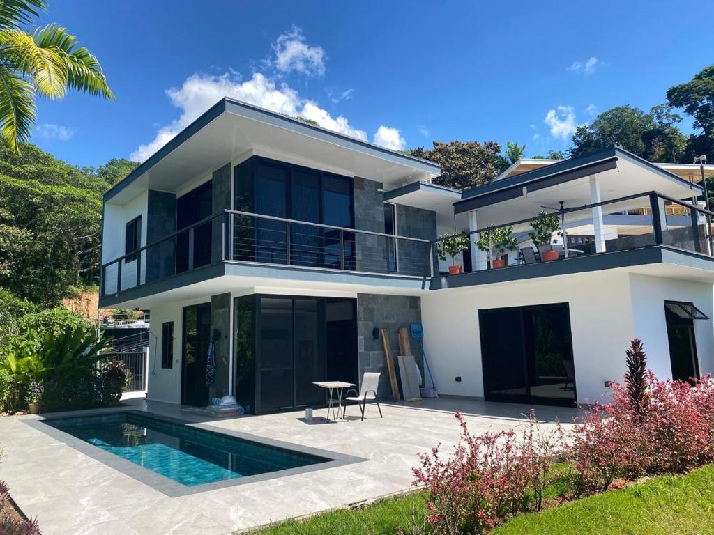 a villa with a swimming pool and a house at Casa Kimara in Uvita