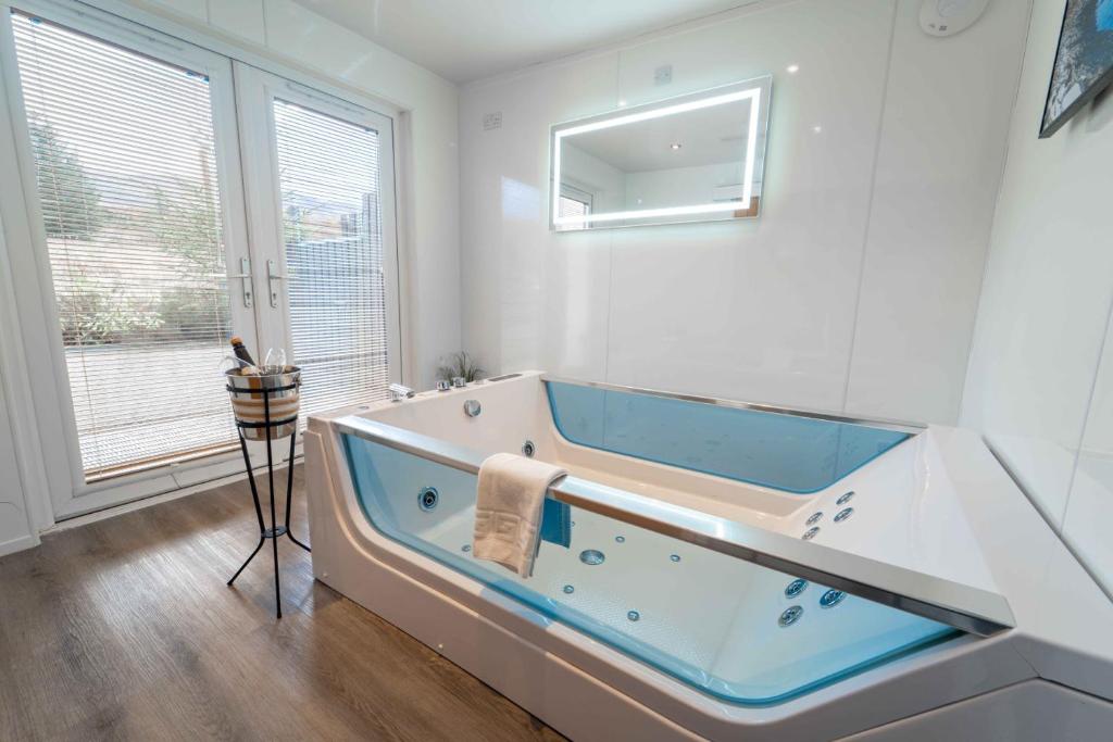 a large bathroom with a tub with a window at Ben View Room and Jacuzzi Bath in Fort William