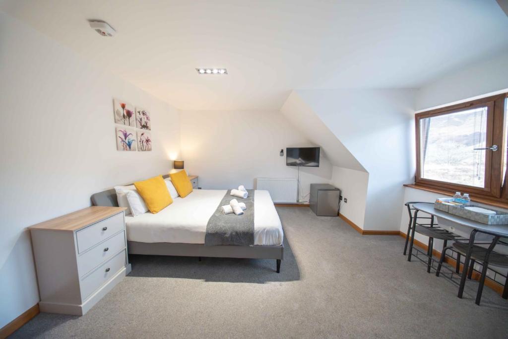 a bedroom with a bed and a desk and a window at Ben View Room 4 in Fort William