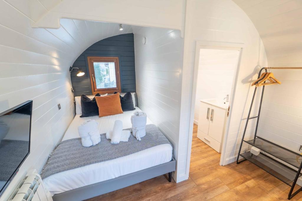 a bedroom with a bed in a white room at Ben View Pod and Jacuzzi Bath in Fort William