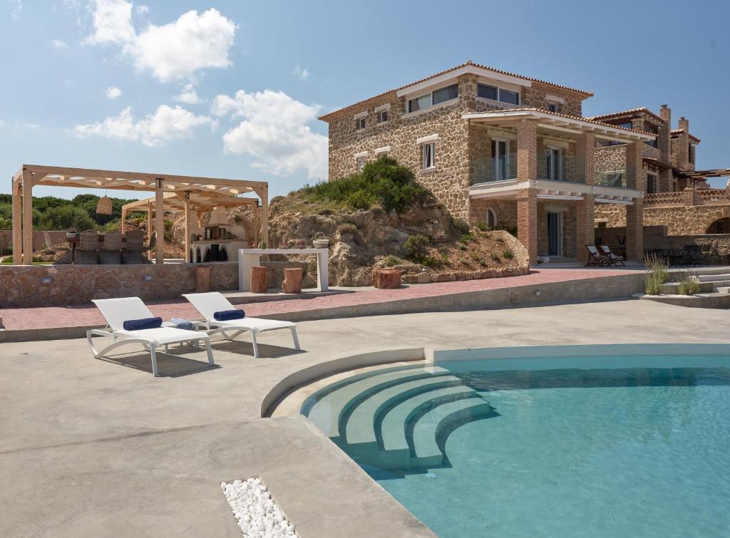 a house with a swimming pool in front of a house at Astarte Villas - Arismari Villas in Vasilikos