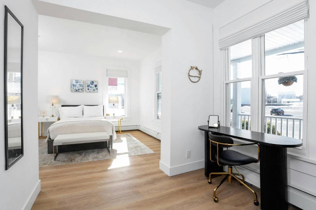 a white bedroom with a bed and a desk at Harbor Haven, Apt #5, 3BR/2BA in Stamford