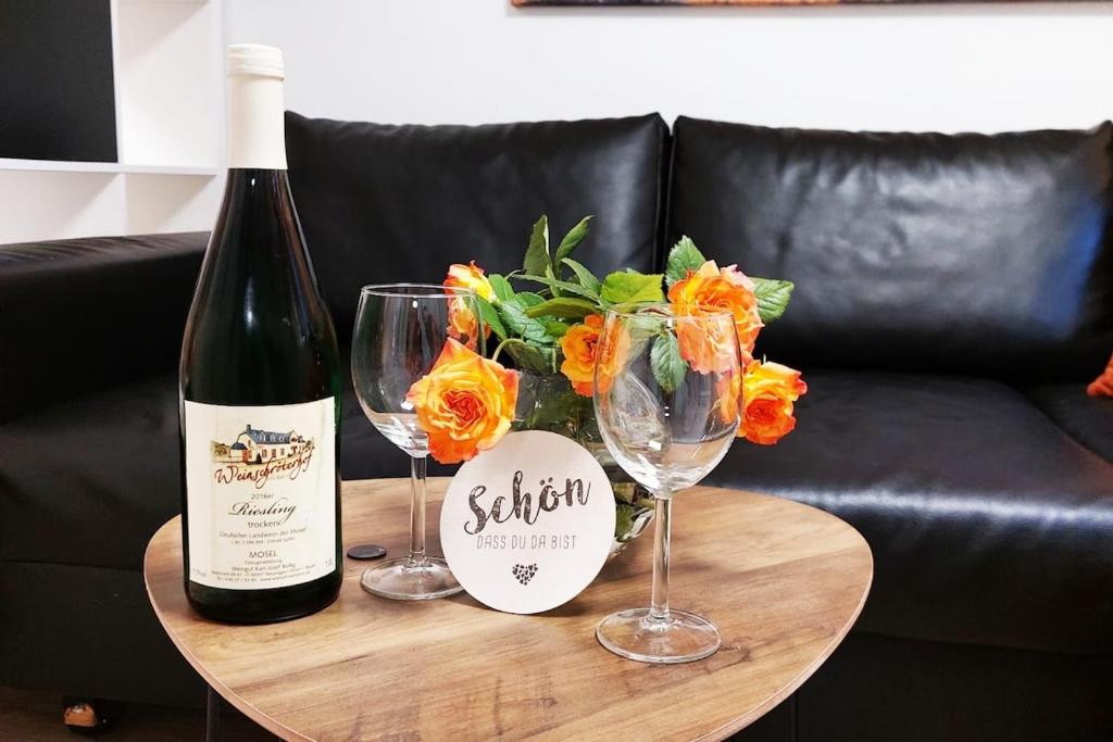 a bottle of wine and two wine glasses on a table at Gemütliches Feriendomizil in Niederorschel