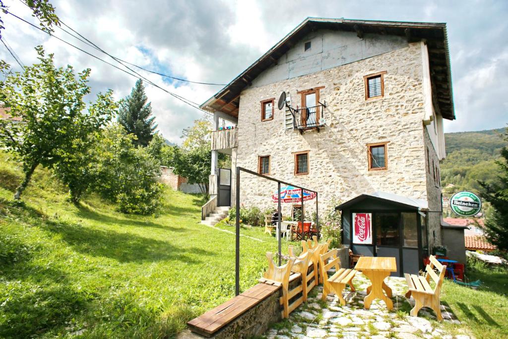 una casa de piedra con sillas y una mesa frente a ella en Yeti (snowman) Guest House, en Mavrovo