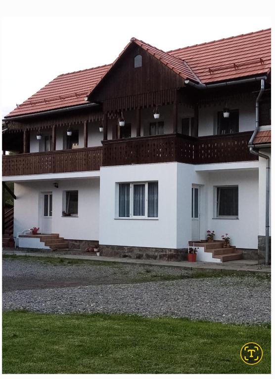 a white house with a brown roof at Enikő vendegház in Praid