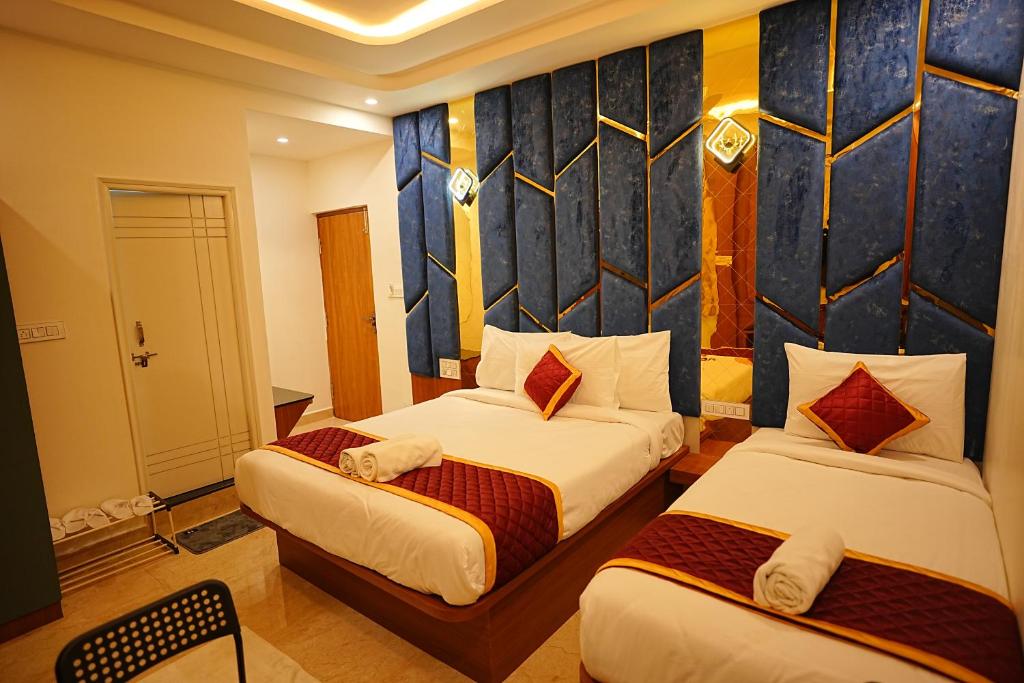a hotel room with two beds and a wall at SN Comforts in Bangalore
