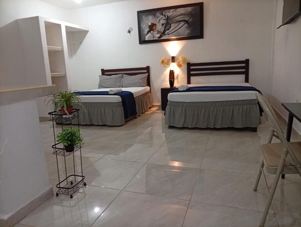 two beds in a room with a tiled floor at Habitaciones Aurelia in Felipe Carrillo Puerto