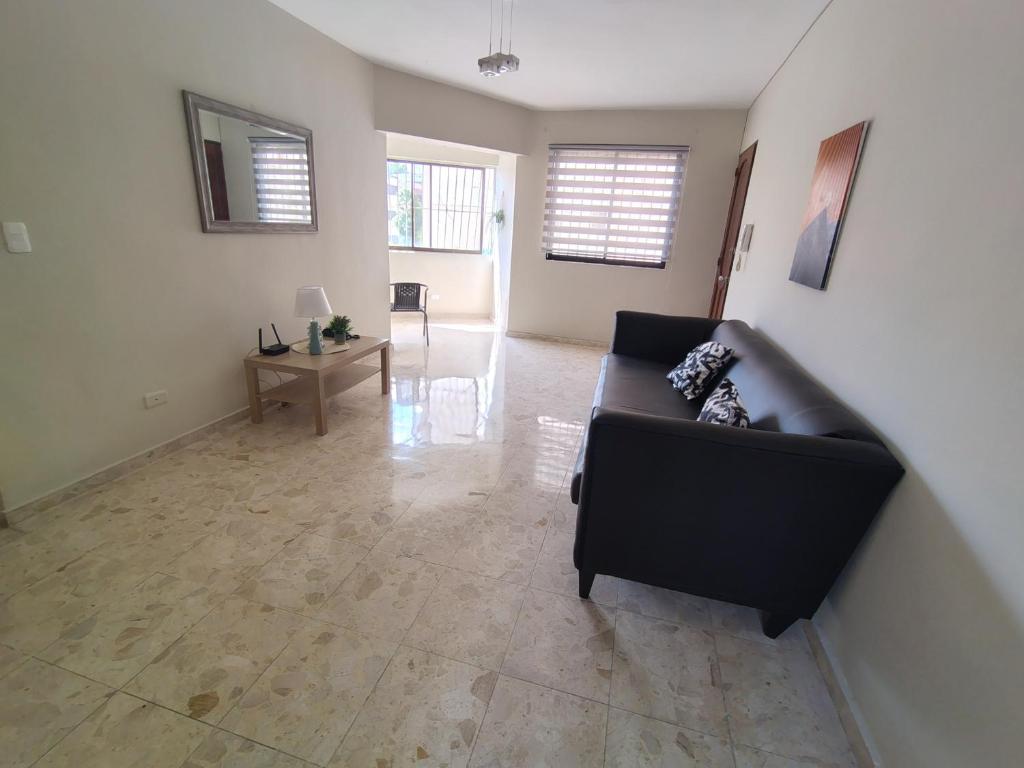 a living room with a couch and a table at Double bed room in Santo Domingo