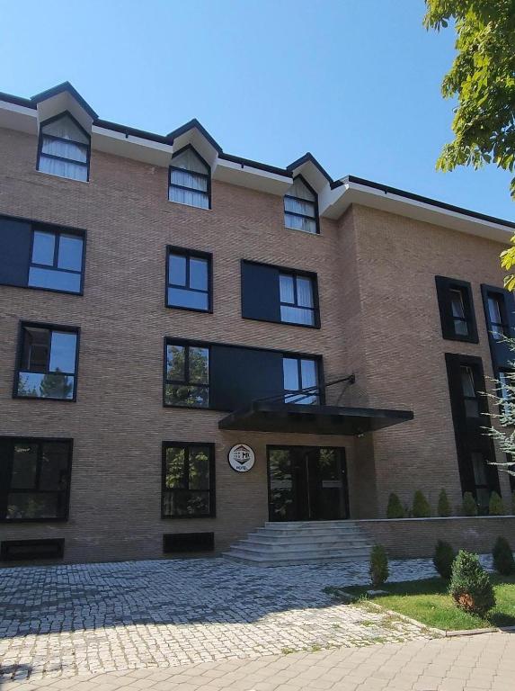 a large brick building with a clock on it at MIK Hotel Korça in Korçë