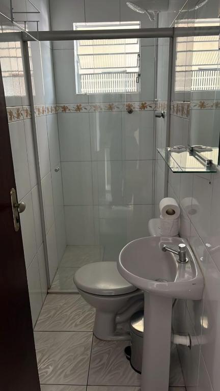 a white bathroom with a toilet and a sink at Hotel Araçariguama in Araçariguama