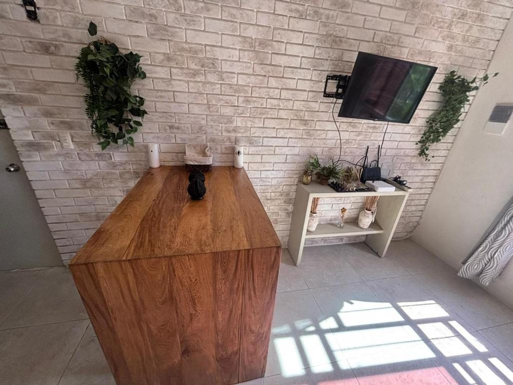 a living room with a wooden table and a tv at Majos Aldea Tulum in Tulum