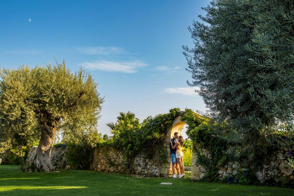 two people standing in front of a stone wall at Casal Sikelio in Cassibile