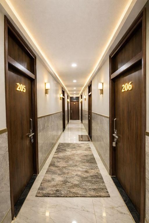 a hallway with two doors and a rug on the floor at Hotel MDP Ayodhya Near Rammandir Ayodhya in Ayodhya