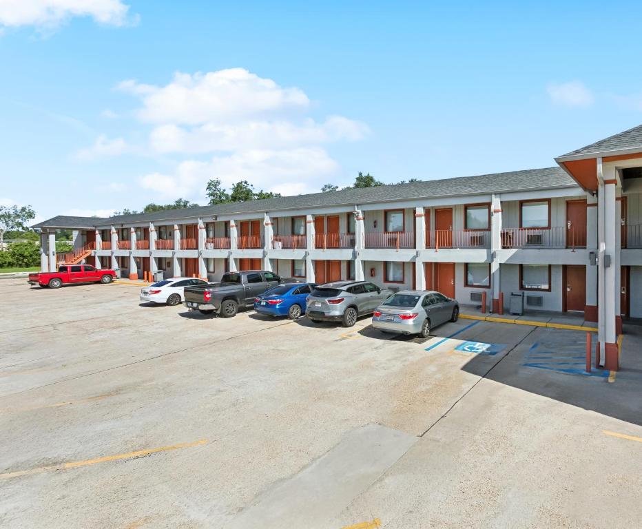 a building with cars parked in a parking lot at Laplace Motel in Laplace