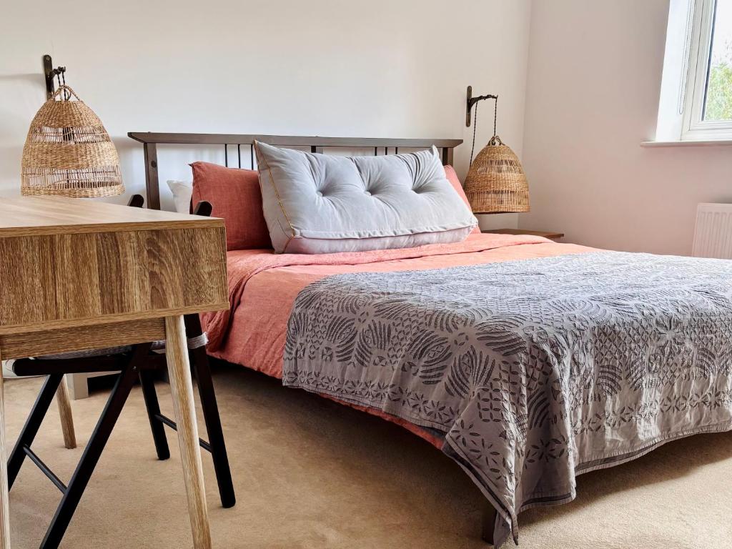 a bedroom with a bed with a wooden table and a desk at Guest Rooms Apsley Lock in Hemel Hempstead