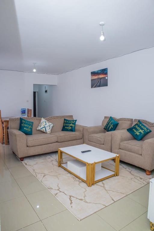 a living room with two couches and a coffee table at Chesum's suites in Eldoret