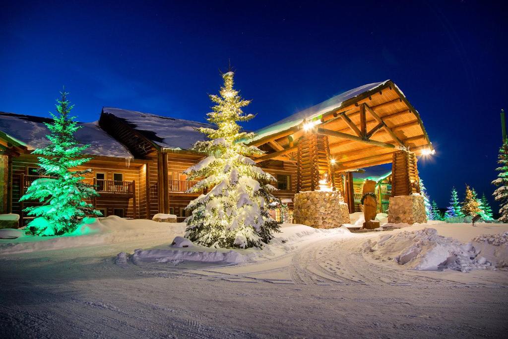 a log cabin with a christmas tree in the snow at Daniels Summit Lodge in Wallsburg