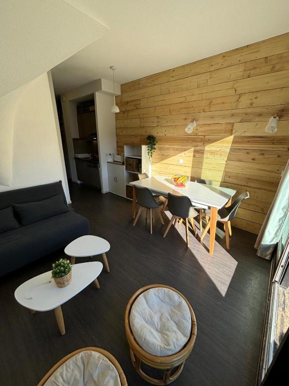 a living room with a couch and a table and chairs at Pied des pistes, piscine, jacuzzi in Flaine