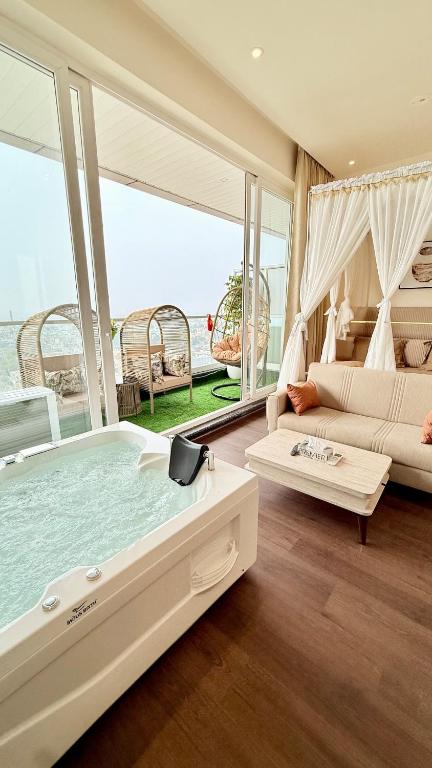 a living room with a large tub in a room with a couch at Sundowner Hive115 Jacuzzi studio Large grdan patio in Gurgaon