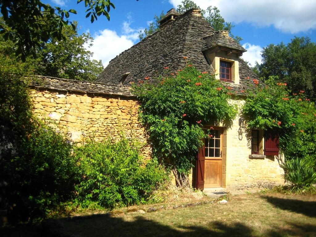 an old stone house with a thatched roof at La Maison du Gardien in La Celle-sous-Gouzon