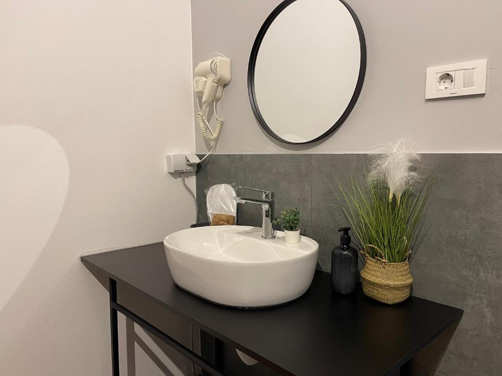 a bathroom with a white sink and a mirror at E - Central Room Five in Skopje