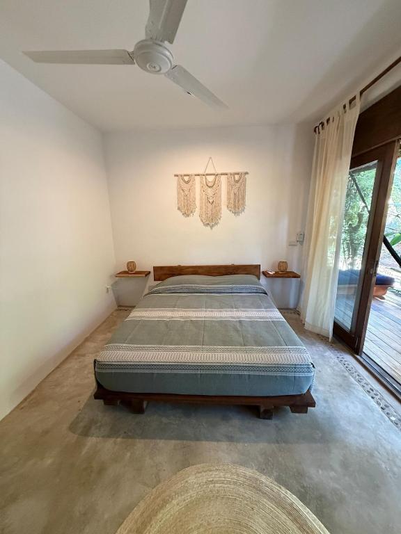a bedroom with a bed in a room with a ceiling fan at Green oasis across from the main street in Mazunte