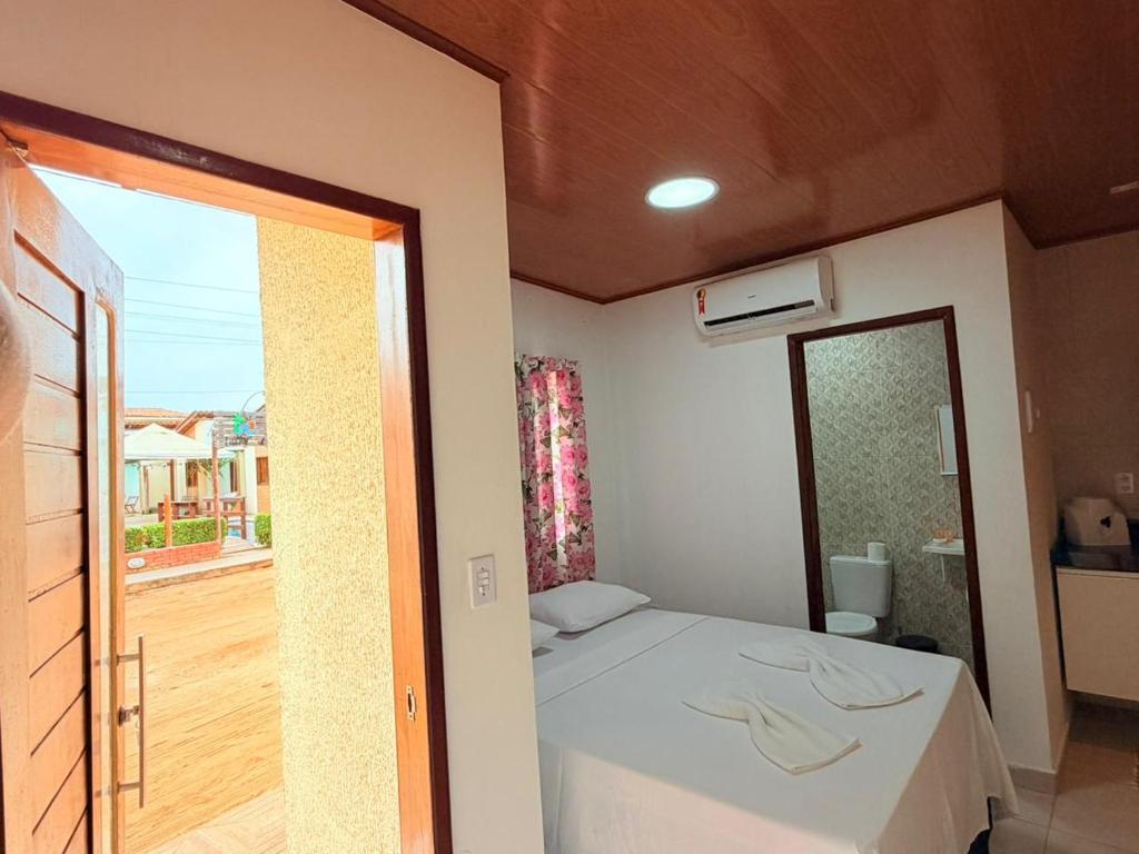 a small bedroom with a bed and a window at Flat Studio Casal - Praia da Lagoa do P a u - Coruripe in Coruripe