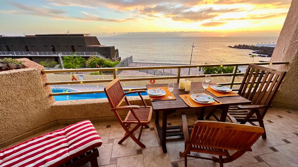 a table and chairs on a balcony with a view of the ocean at Serigor Bahía Ocean View in Puerto de Santiago
