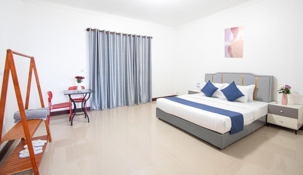 a bedroom with a bed and a table and a chair at Private pool Villa3rooms in Siem Reap