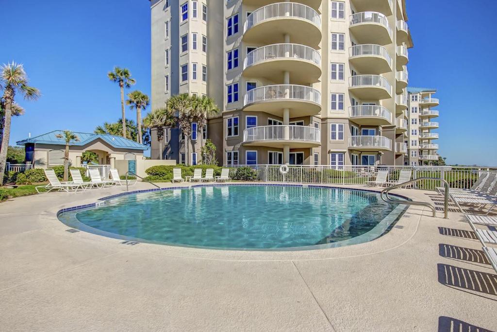 a large apartment building with a swimming pool in front of it at Oceanfront 5th-floor condo with balcony, gorgeous views & pool access in Fernandina Beach